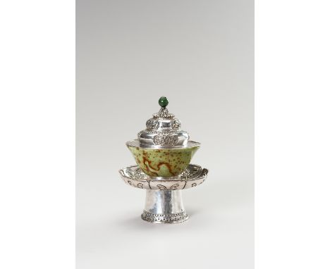 A SILVER AND JADE BUTTER TEA SETTibet, around 1900 to 1920. The silver stand with the lobed saucer atop, embossed with floral