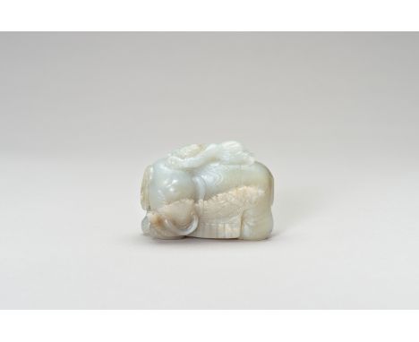 A PALE CELADON JADE CARVING OF AN ELEPHANT AND BOYChina, late Qing Dynasty (1644-1912) to Republic period (1912-1949). Finely