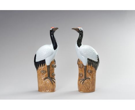A PAIR OF PORCELAIN FIGURES OF CRANESChina, late Qing Dynasty (1644-1912). Both red hooded cranes perched on a tree trunk, wi