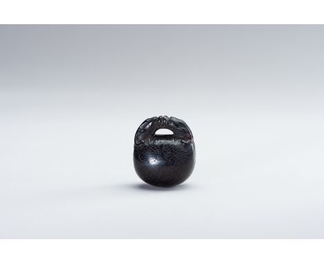 A DARK WOOD NETSUKE OF A MOKUGYOJapan, 19th centuryThe dark wood netsuke depicting a mokugyo (temple bell) with neatly incise