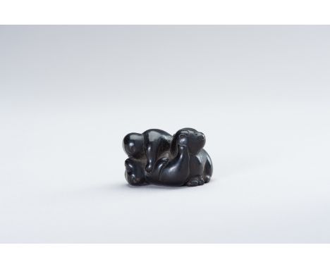 A DARK WOOD NETSUKE OF PUPPIESJapan, Meiji period (1868-1912) The charming dark wood netsuke of three small puppies playing a
