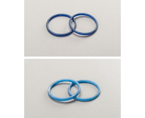 FOUR BLUE GLASS BANGLESChina, Han Dynasty or later. Of circular form, two of dark blue color and two of light blue color. Con