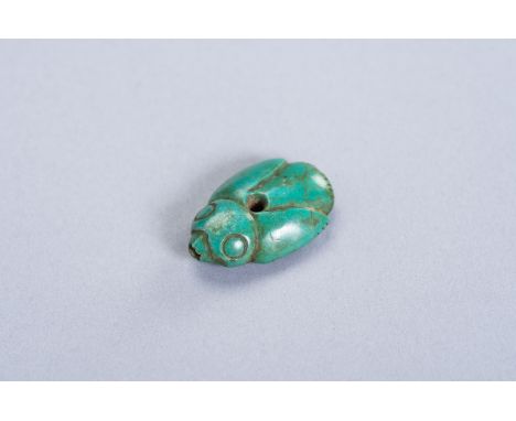 A TURQUOISE PENDANT OF A BIRDChina, Shang Dynasty (1600 - 1046 BC) or later. Simplistic depiction of an oval and flattened bi