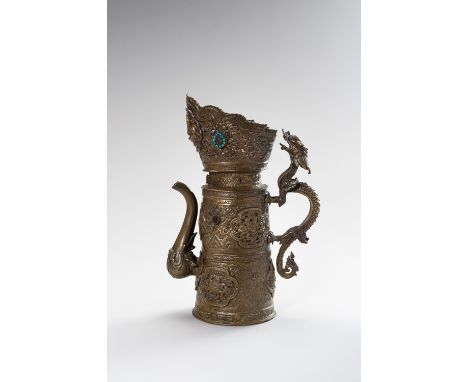 A BRASS REPOUSSE BEER EWERTibet, late 19th century. The cylindrical body rising from a flat base to a partially reticulated c