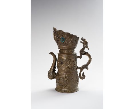 A BRASS REPOUSSE BEER EWERTibet, late 19th century. The cylindrical body rising from a flat base to a partially reticulated c