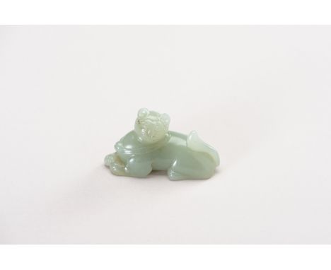 A CELADON JADE CARVING OF A DOMESTIC CATChina, 18th century or earlier. The smoothly polished semi-translucent celadon jade d