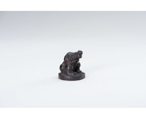 A WOOD NETSUKE OF BAKU ON A BASEJapan, 19th centuryThe wood netsuke of the nightmare-devouring Baku, seated on a low round ba