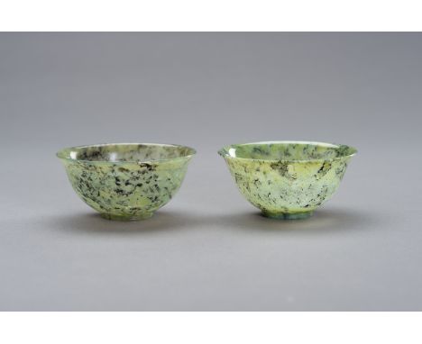 A MOTTLED PAIR OF JADE BOWLSChina, late Qing to Republic period (1880-1950). The thin rounded sides rising from a straight ri