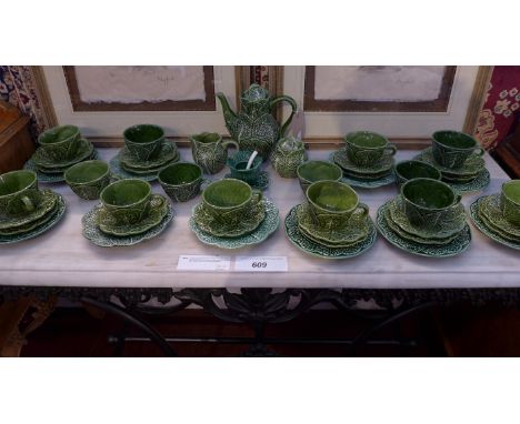 A collection of Portuguese majolica teaware including a teapot, milk jug, sugar bowl, cups, saucers and plates