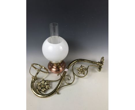 A brass oil lamp wall bracket together with an oil lamp and shade