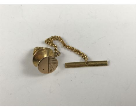 A gentleman’s 9ct gold solitaire / tie pin, having engine turned decoration and gilt metal fastening
