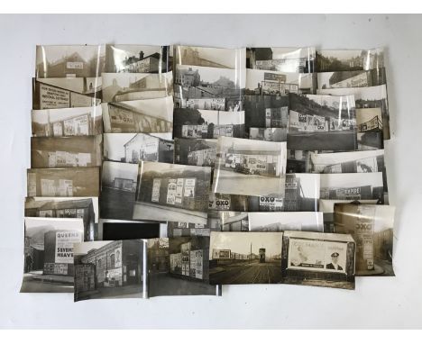 A glass plate negative and a large number of monochrome photographs of enamel and other advertising signs around Whitehaven a