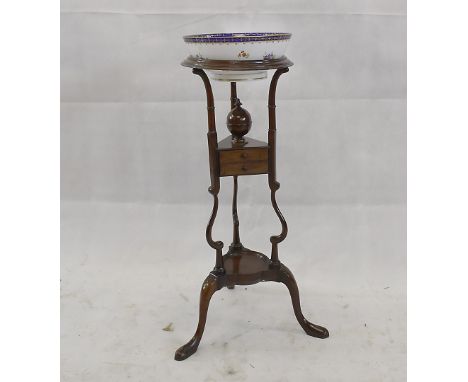 A George III style mahogany tripod washstand, on turned supports with cabriole legs united by lower tier and drawer section, 
