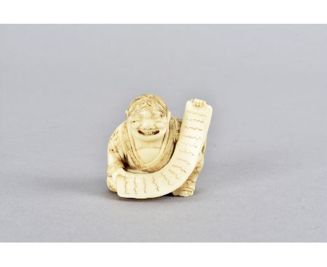 A Tokyo School Late Meiji period carved ivory Netsuke figure, in the form of a seated gentleman smiling, holding an unwound s