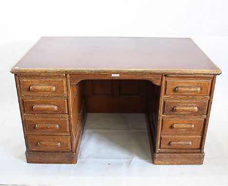 An early 20th Century oak pedestal partners desk, by Thomas Turner, the leatherette inset top supported by two pedestals with
