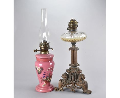 A 19th Century cast iron and glass oil lamp, having three lion and shield legs with column design, together with another in g