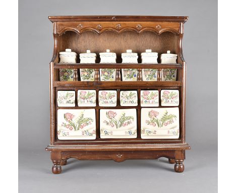 A continental stained beech and pottery spice rack, having floral decorated ceramic drawers and covered pots, 55 cm high x 50