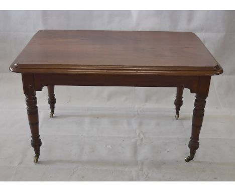 A late Victorian mahogany table, of rectangular form on turned tapering legs and brass and ceramic castors, 126 cm x 79 x 75 