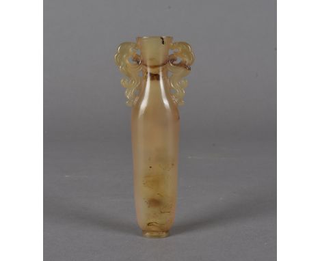 A 17th Century Chinese agate tear vase, the ovoid slender body with inverted neck and flared rim having carved dragon scrolle