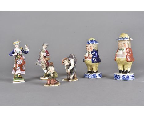 A pair of Sitzendorf porcelain figures, one modelled as a hunchback, the other as a dwarf playing cards, together with a pair