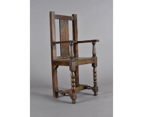 An apprentice made oak miniature carver chair, having bobbin front legs, beading to seat edges, turned arm supports, 41 cm hi