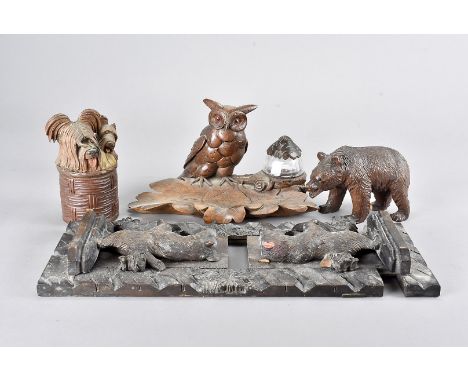 A Black Forest carved bear book trough, 39 cm long together with an owl carved desk set with pen tray, a dog carved box and c