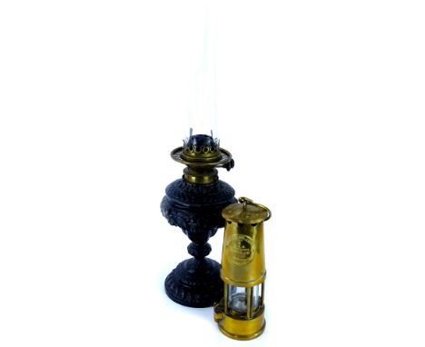 A Victorian ebonised spelter on a lamp base, with brass fitting, 33cm high, a glass chimney and a protector brass oil lamp.