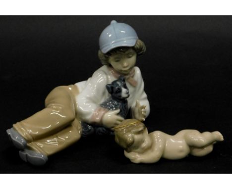 A Lladro porcelain reclining angel or cherub, and a Nao porcelain figure of a young boy reclining with a dog.