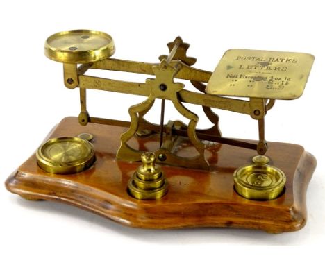 A set of late Victorian walnut and brass postal scales with weights, 18cm wide.
