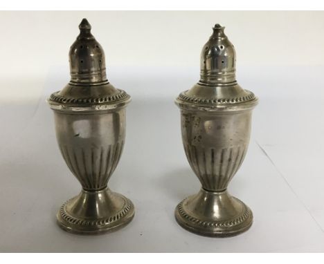 Two loaded silver condiments, with flutted sides, marked Sterling Silver.