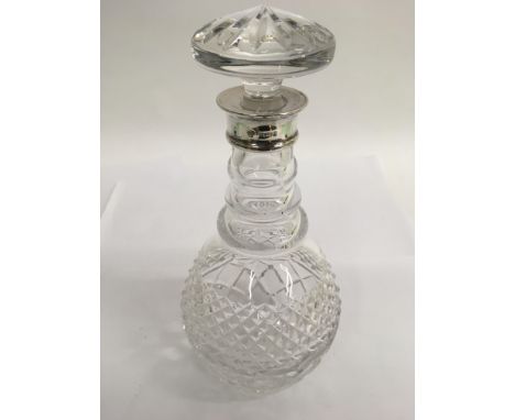 A cut glass decanter with silver mount