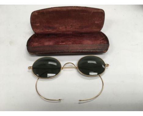 A pair of vintage sunglasses, possible gold rims.