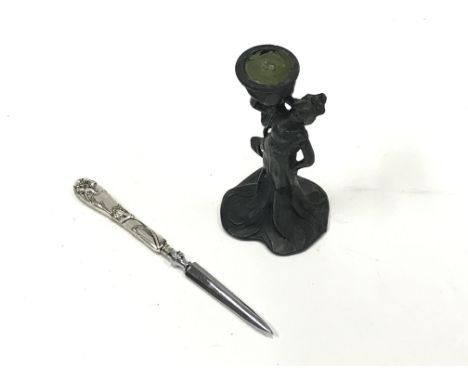 A metal Art Nouveau candlestick of a draped female holding candle holder on shoulder and a silver plated paper knife with Art