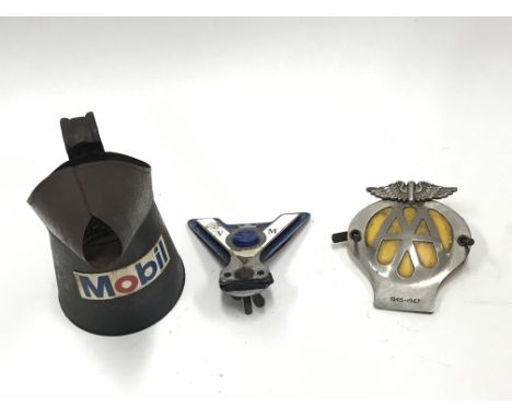 Two car badges and a Mobil oil can