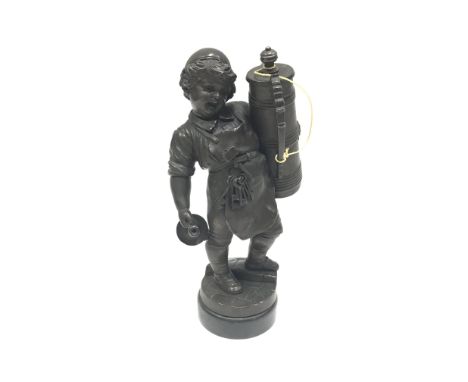 A fine quality bronzed metal table lighter. The figure of a young man is holding a candlestick and has an apron with a bunch 