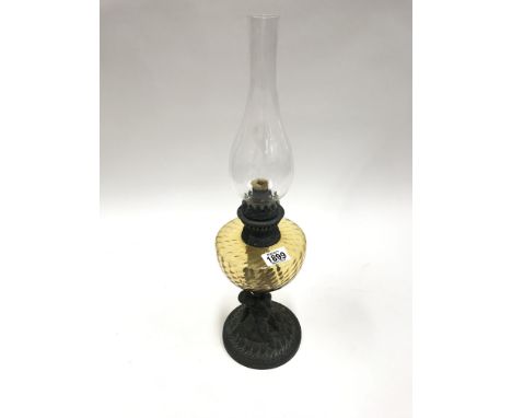 A Victorian oil lamp with cherub on base supporting lamp, glass reservoire and chimney