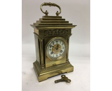 A brass cased eight day mantle clock with an enamel dial, approx 19cm.