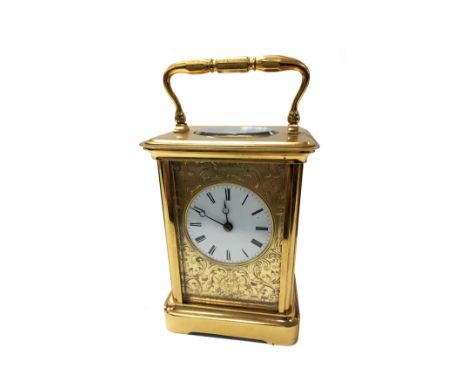 A leather cased carriage clock with key and Roman numerals.