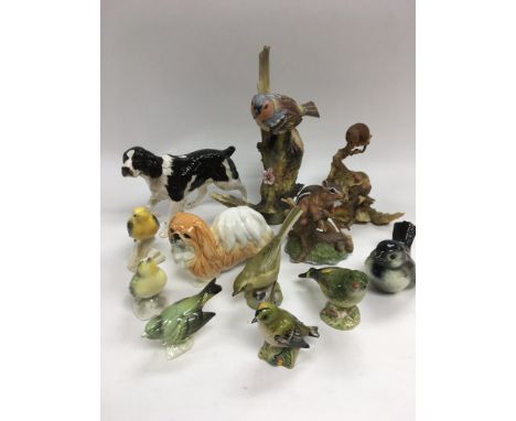 A collection of ceramic animal figures including a Royal Doulton dog, Sylvac dog, seven bird figures and others.