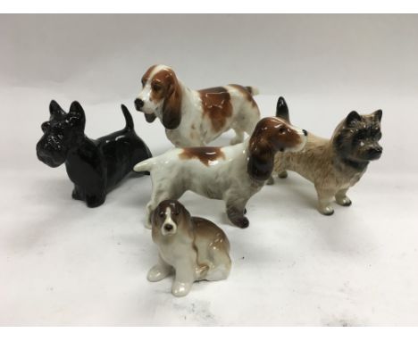 A collection of five ceramic dogs by Royal Doulton, Beswick and Lomonosov.