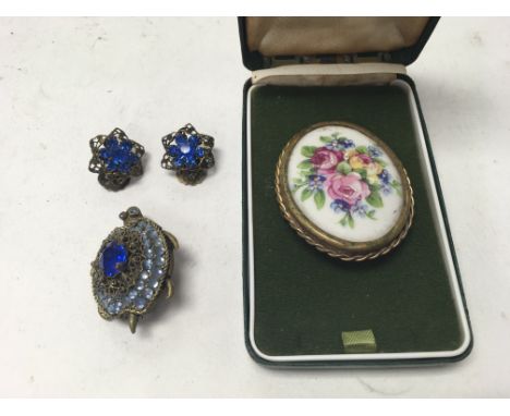 A vintage dress jewellery brooch set with blue stones and a Limoges oval brooch.