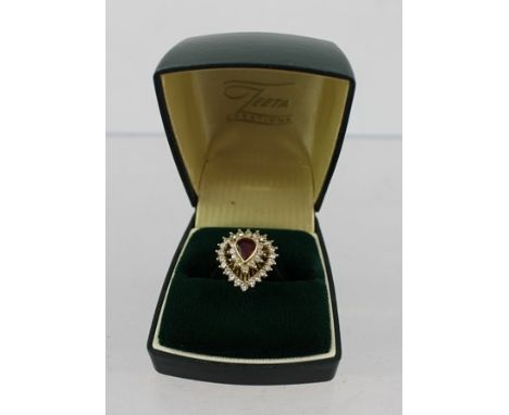 A RUBY AND DIAMOND GOLD COLOURED METAL DRESS RING, fashioned as a heart with central fancy cut ruby bordered by two rows of d