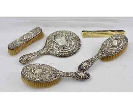 AN EDWARDIAN EMBOSSED SILVER MOUNTED FIVE PIECE DRESSING SET, includes hand mirror, comb and brushes, Chester 1905 