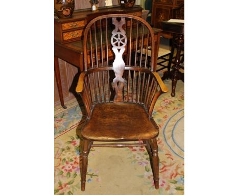 A 19TH CENTURY DOUBLE COMB WHEEL BACK COUNTRY ARMCHAIR of typical form and construction, with well figured seat, on four spla