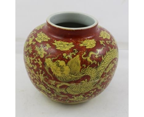 A CHINESE SQUAT CERAMIC VASE decorated with yellow dragons on a brick red ground, bears character marks to base, 14cm high 