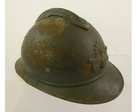 A FRENCH FIRST WORLD WAR HELMET bears grenade and crossed artillery barrel, the crest monogrammed "RF" 