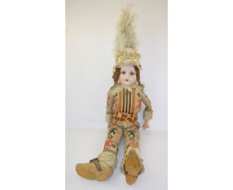 AN EARLY 20TH CENTURY GERMAN DOLL, having composition and wood wool body, dressed in bell mounted patch sewn costume with woo