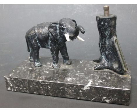 A mid 20th century Austrian spelter table lighter in the form of an elephant by a tree, 15cm long