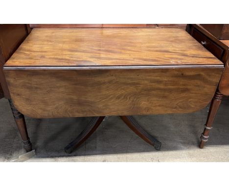 A Regency mahogany sofa table, with a rectangular top and drop flaps above a frieze drawer on a turned column and four splaye