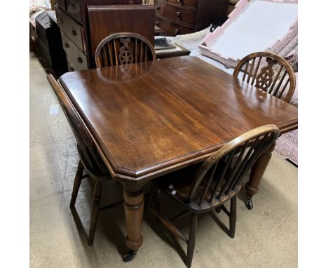 An Edwardian mahogany extending dining table on turned tapering legs and casters with an additional leaf together with a set 